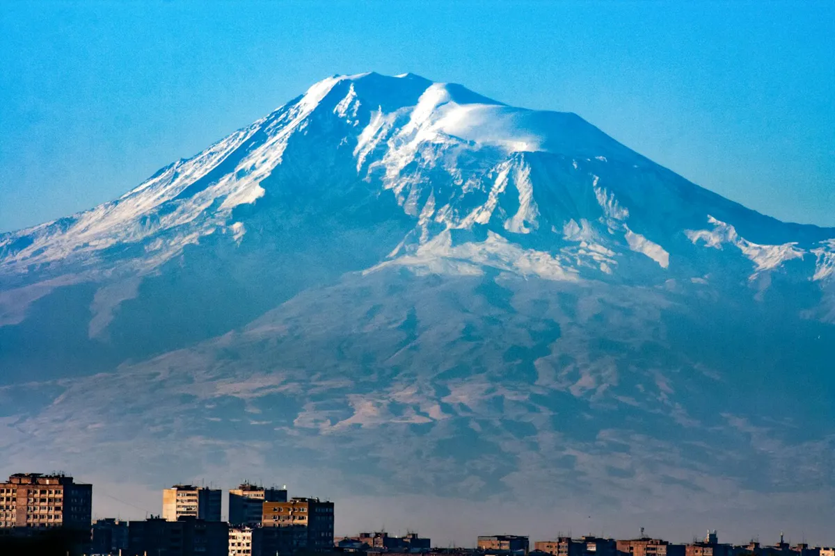 Stunning view of Mount Ararat covered in snow, towering over Yerevan cityscape in Armenia.