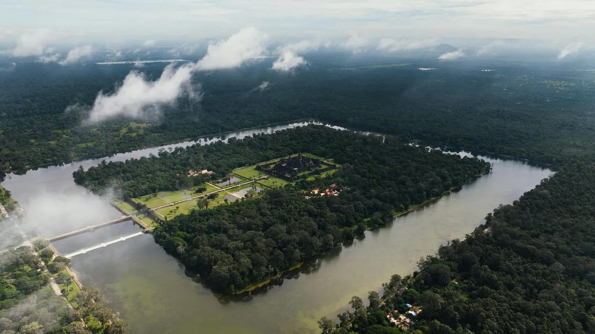Breathtaking aerial view of Angkor Wat, encircled by dense forests and a moat in Siem Reap, Cambodia.