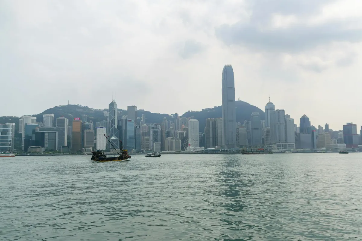 Stunning Hong Kong skyline view across Victoria Harbour with traditional junk boat