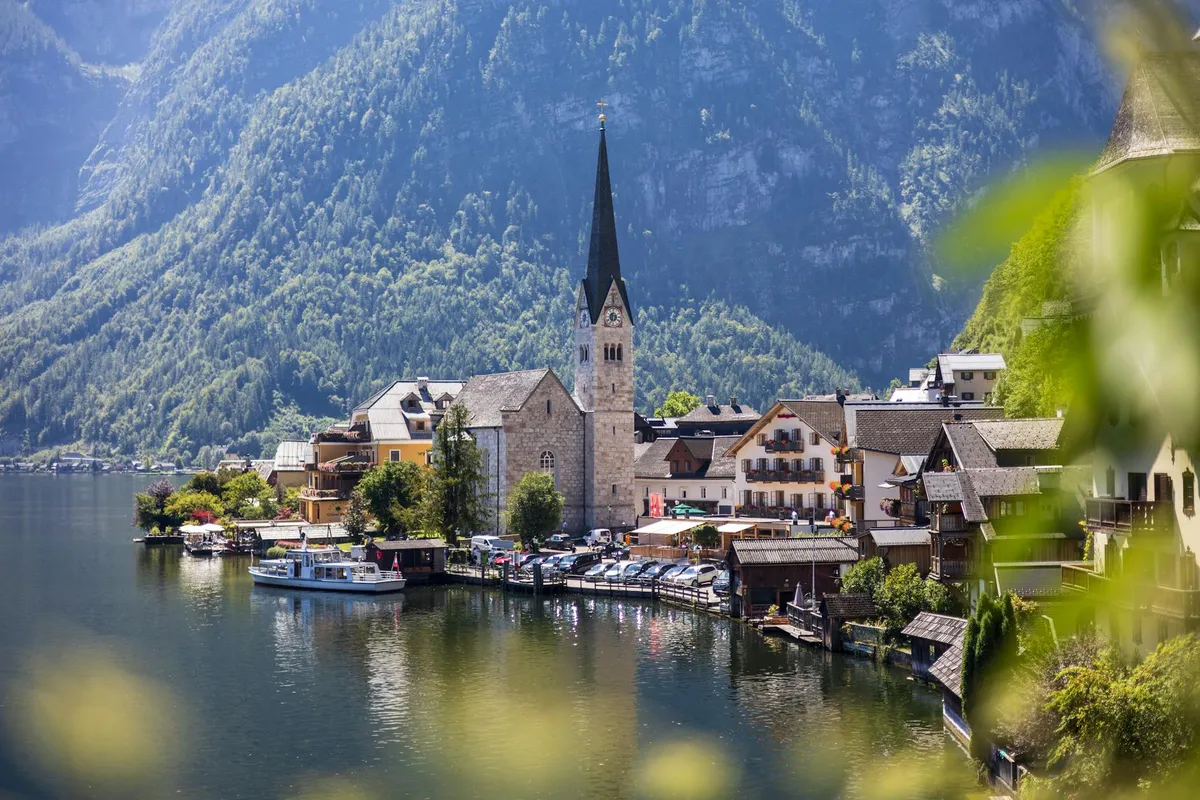 Stunning summer view of Hallstatt village by the lake, surrounded by the Alps.