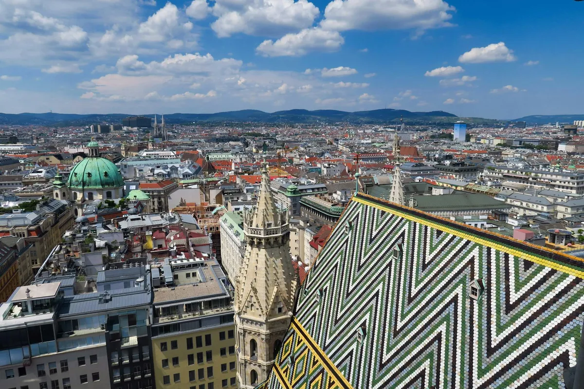 Stunning aerial perspective of Vienna cityscape with St. Stephen's Cathedral, vibrant rooftops, and clear skies.