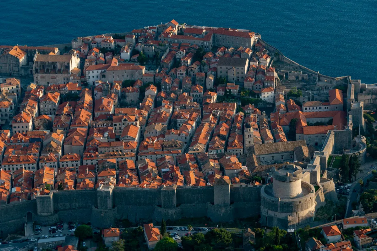 Breathtaking aerial shot of Dubrovnik's historic Old Town, showcasing ancient city walls and red-tiled roofs.