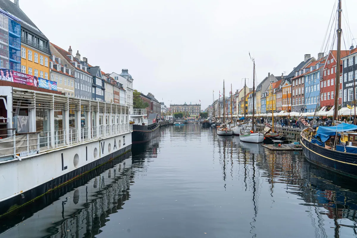 A stunning view of Nyhavn in Copenhagen featuring colorful buildings and classic boats along the canal.