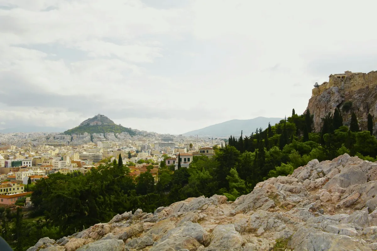 Stunning vista of Athens with the Acropolis and lush greenery in the foreground.