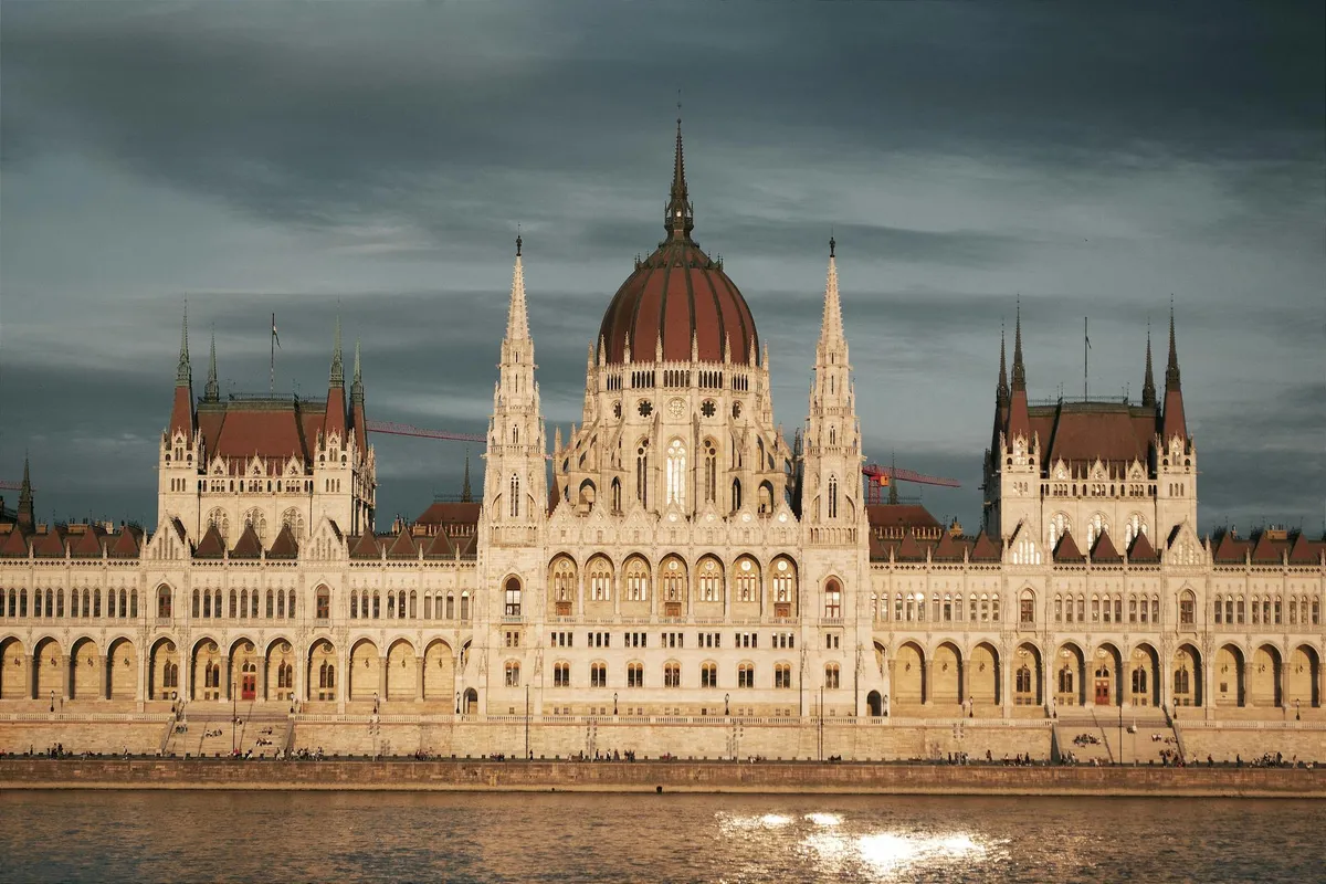 Captivating view of the Hungarian Parliament Building in Budapest, reflecting on the Danube River at sunset.