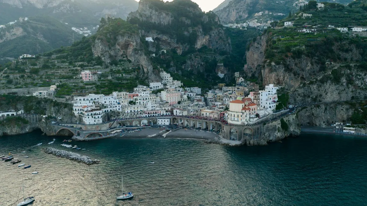 A stunning aerial view of Atrani, a picturesque village on Italy's Amalfi Coast, surrounded by cliffs and sea.