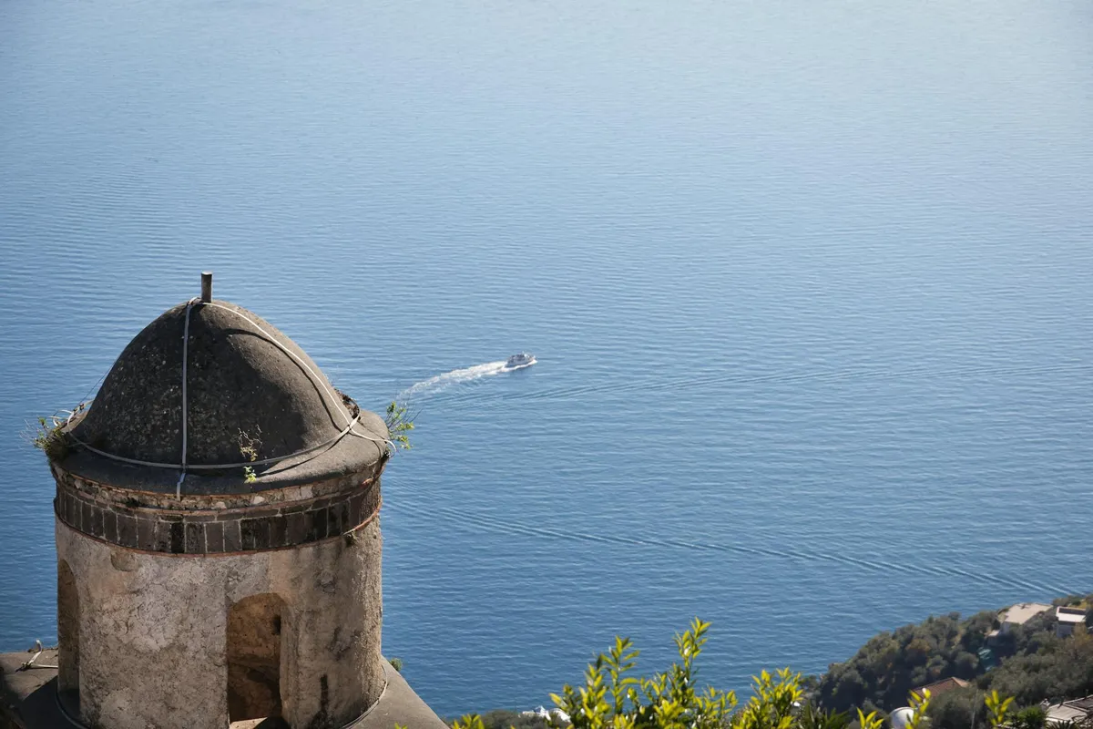 A picturesque view of the Amalfi coast featuring a historic tower overlooking the sea.