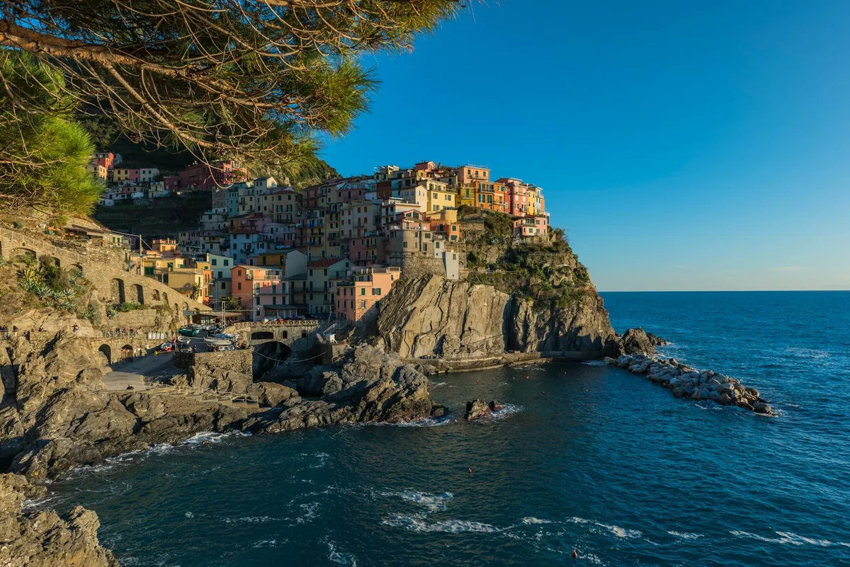 Stunning view of colorful Manarola perched on the rugged cliffs of Cinque Terre at sunset.