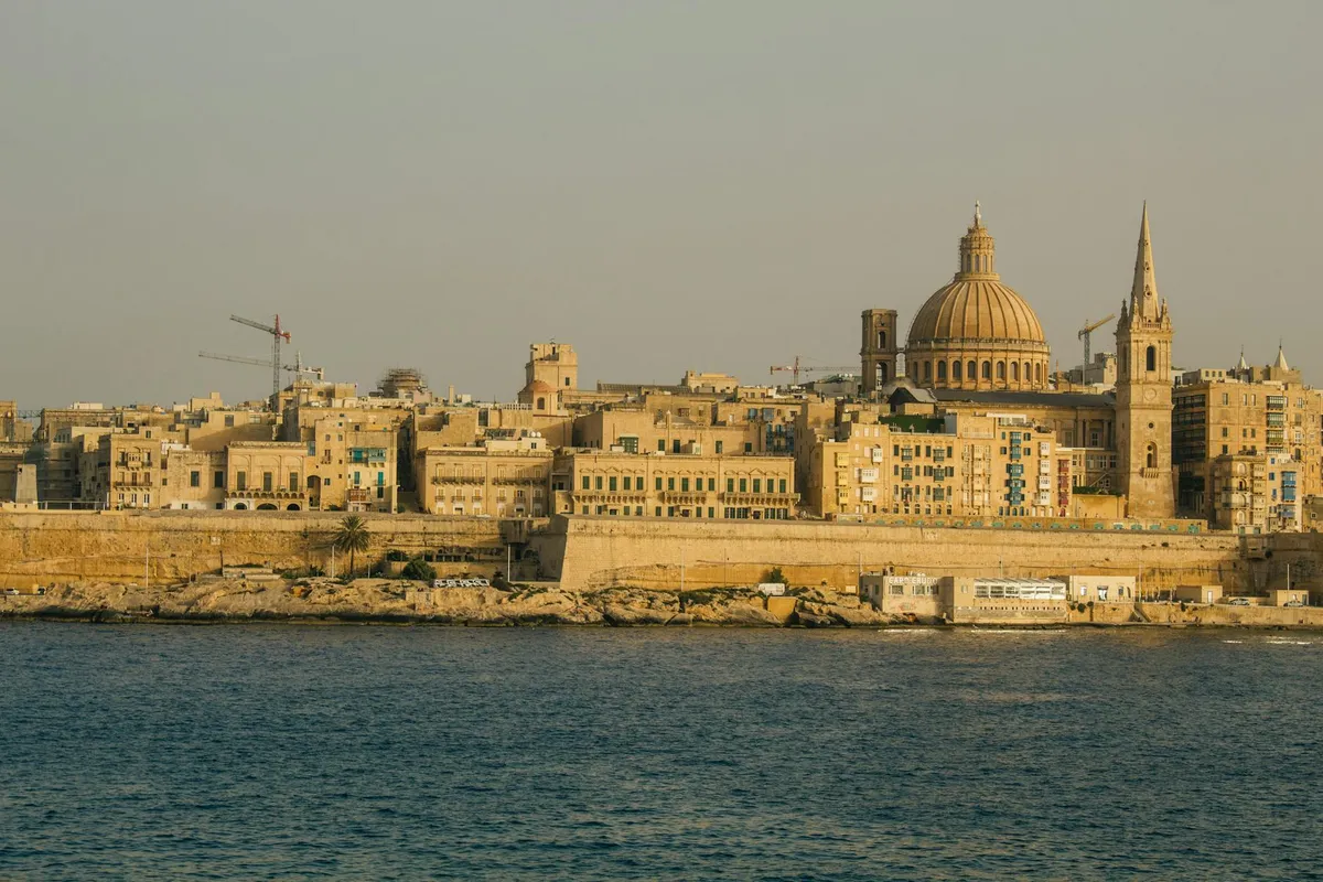 Stunning view of Valletta's historic skyline with St. Paul's Cathedral at sunset.