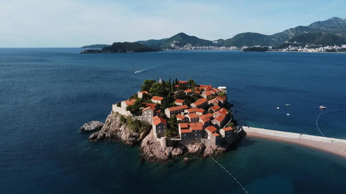 Breathtaking aerial view of the iconic Sveti Stefan island in Montenegro, surrounded by turquoise waters.