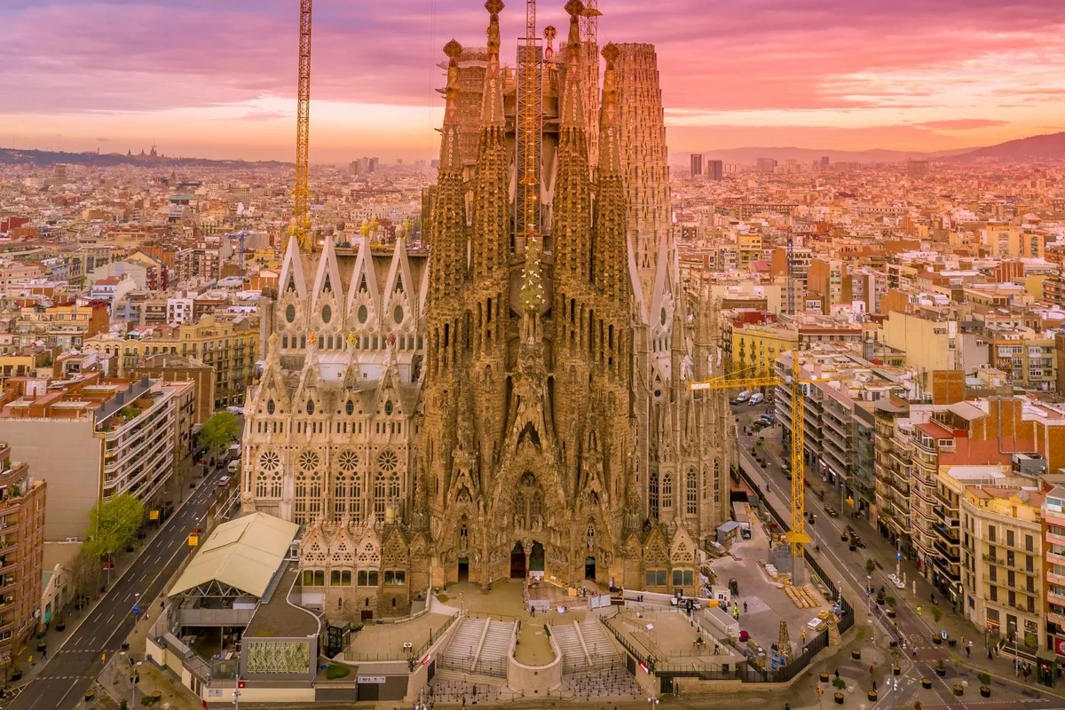 A breathtaking aerial capture of the Sagrada Familia in Barcelona during a vibrant sunset.