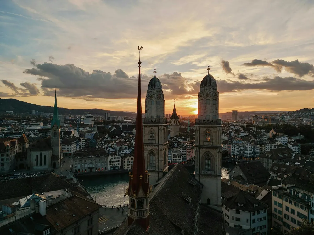 A breathtaking aerial view of Zurich with iconic landmarks during a stunning sunset.