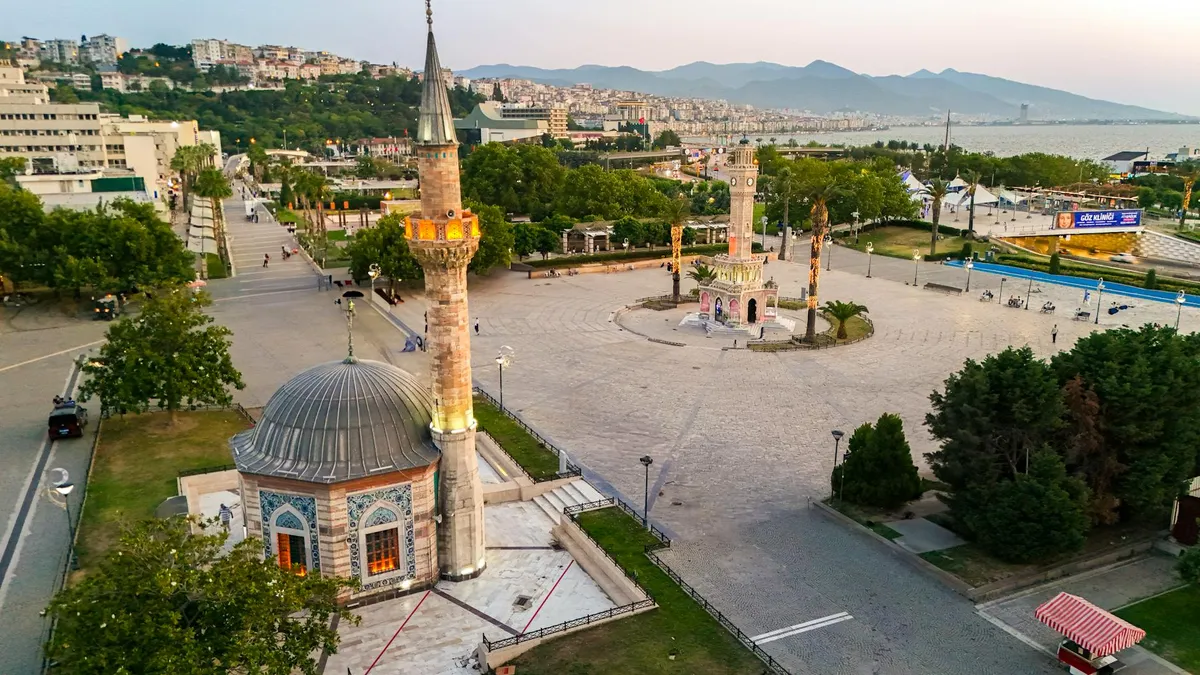 Aerial shot of Konak Square and the iconic Clock Tower in İzmir, Türkiye during twilight.